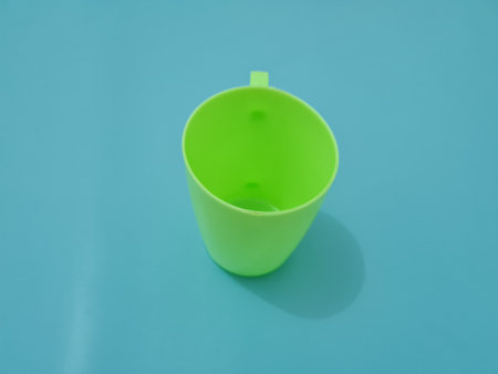 A glass made of plastic with a green handleの写真素材
