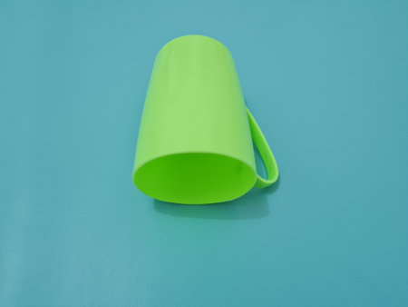 A glass made of plastic with a green handleの写真素材