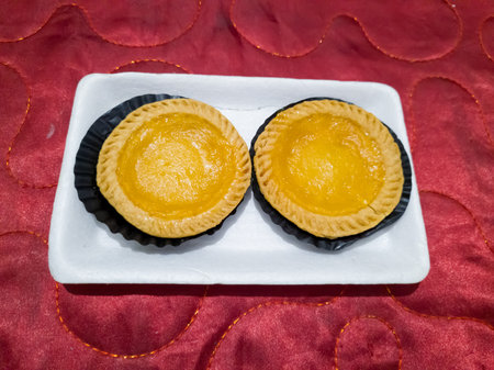 Soft sweet milk pie in a white container on a red cloth backgroundの写真素材