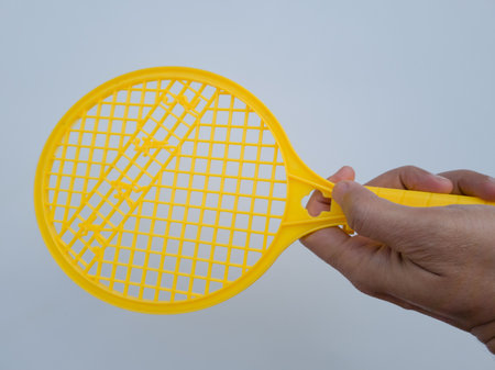 Yellow children's toy plastic racket on a white backgroundの写真素材