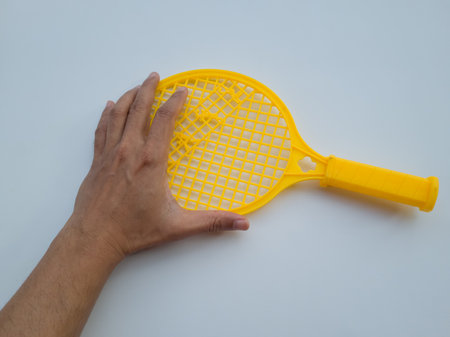 Yellow children's toy plastic racket on a white backgroundの写真素材