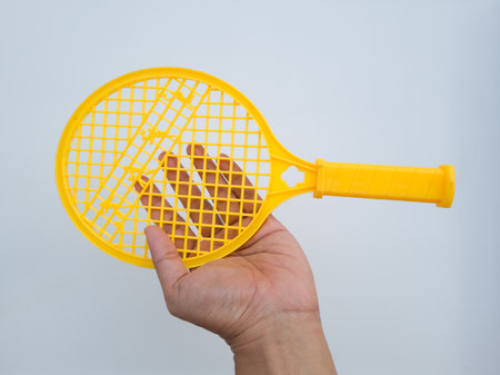 Yellow children's toy plastic racket on a white backgroundの写真素材