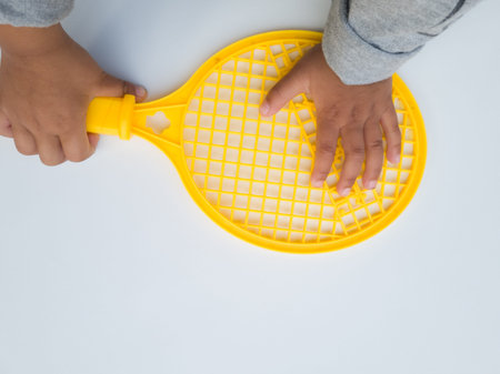 Yellow children's toy plastic racket on a white background