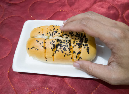 Bread sprinkled with chocolate sprinkles in a white container with a red backgroundの写真素材