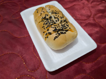 Bread sprinkled with chocolate sprinkles in a white container with a red backgroundの写真素材