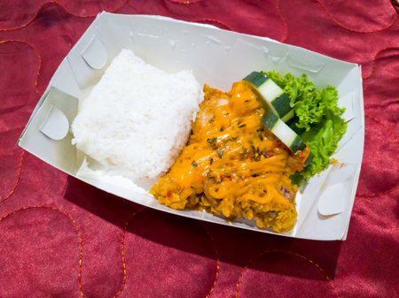 Chicken rice sprinkled with cheese mayonnaise in a white paper containerの写真素材