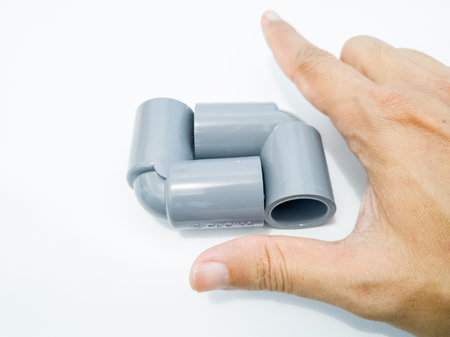 plastic pipe in hand on a white background close-up.