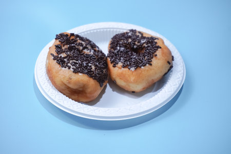 donut cake sprinkled with chocolate sprinkles in a white containerの写真素材