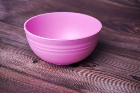 Empty pink bowl on wooden background. Selective focus. Toned.の写真素材