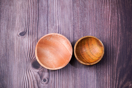 Wooden bowl on wooden background. View from above. Selective focus.の写真素材