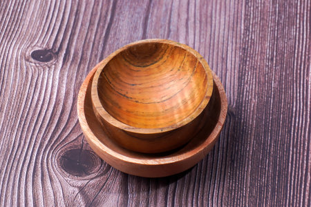 Wooden bowl on wooden background. View from above. Selective focus.の写真素材
