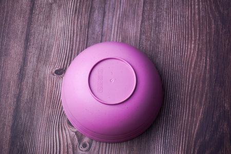 Empty pink bowl on wooden background. Selective focus. Toned.の写真素材
