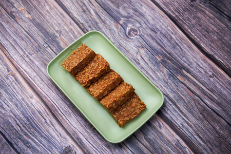 Fried tempeh in a container on a wooden table