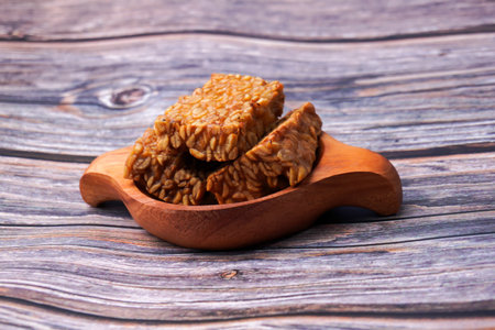Fried tempeh in a container on a wooden tableの写真素材