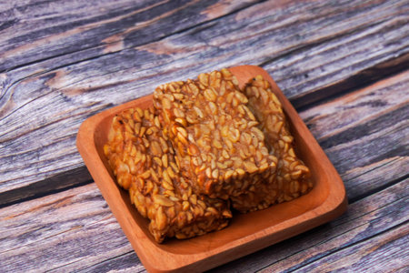 Fried tempeh in a container on a wooden tableの写真素材