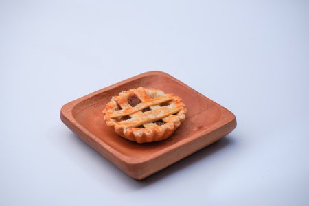 Apple pie on wooden plate isolated on white background. Selective focus.の写真素材