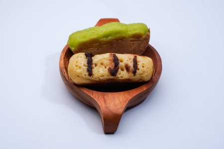 Eclairs on a wooden plate on a white background, isolate