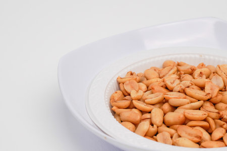 Roasted peanuts in white dish on white background with copy space.の写真素材