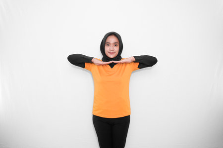 Warm-up expression of gymnastics by bending both arms to the side with the shoulders straight of an Asian woman in a yellow shirtの写真素材