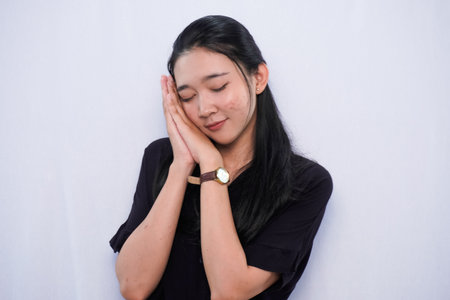 Expression of Asian woman in black dress sleeping on white backgroundの写真素材