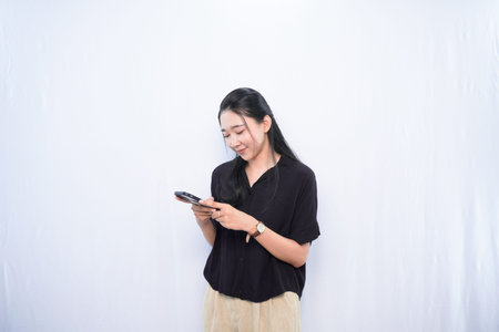 Expression of Asian woman in black dress chatting using smartphone with white background