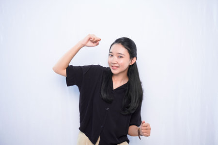 Asian woman in black dress showing success expression on white backgroundの写真素材