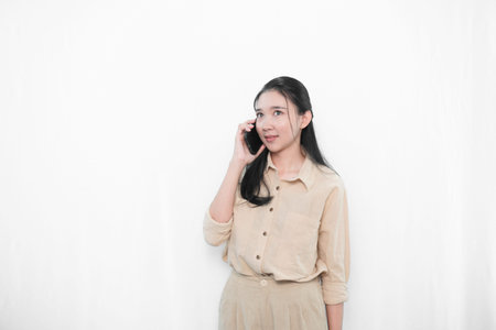 Expression of an Indonesian Asian model woman in white is making a phone call with a smartphone