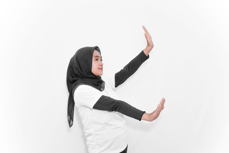 Movements of women wearing hijabs in white clothes, hands forward, one up, one down