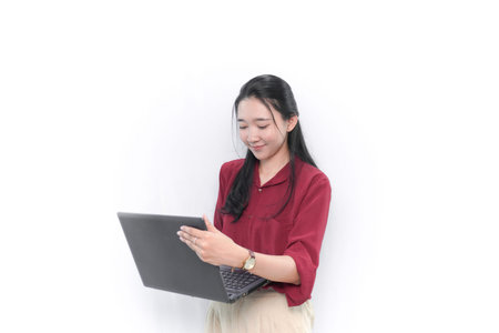 Indonesian Asian woman in red dress smiling and using laptop
