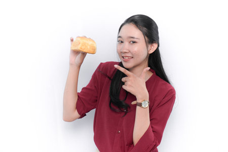 Asian woman in red dress smiling and holding breadの写真素材
