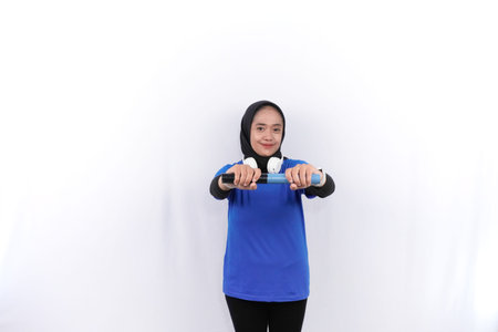 Indonesian Asian woman wearing a hijab in blue is warming upの写真素材