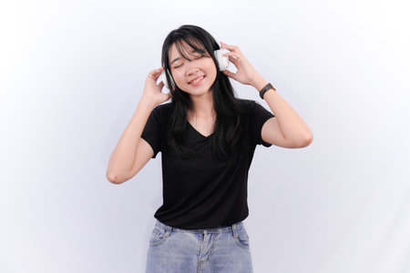 Asian woman wearing black top listening to musicの写真素材