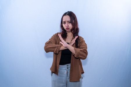 Indonesian Asian woman in brown shirt crosses her armsの写真素材