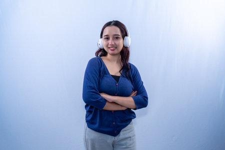 Indonesian Asian woman in blue dress smiling and listening to musicの写真素材