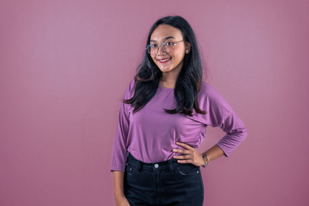 Asian Indonesian woman wearing purple dress smiling and putting her hands on her hips