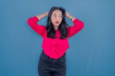 Indonesian Asian woman in red dress is confused or stressed