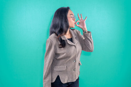 Indonesian woman wearing brown jacket giving sign