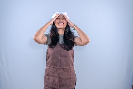 Indonesian Asian woman wearing cooking clothes giving an expression of disbeliefの写真素材
