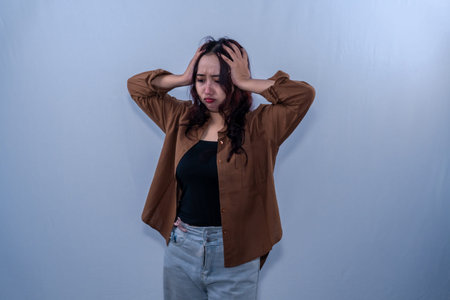 Indonesian Asian woman in brown dress has a headache or dizziness