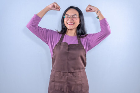 Indonesian Asian woman wearing purple clothes plus brown apron makes the code successfulの写真素材