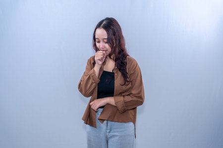 Asian Indonesian woman wearing brown clothes is sick with cough
