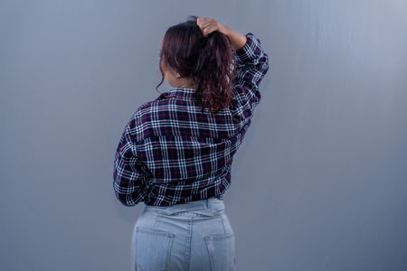 Asian Indonesian woman wearing green clothes holding her hairの写真素材