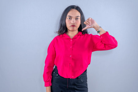Indonesian Asian woman wearing red clothes giving a signal