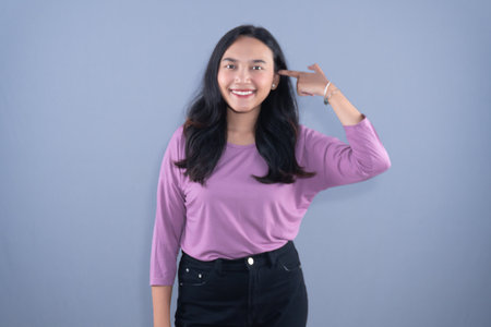 A smiling woman in a lavender shirt poses for the photoの写真素材