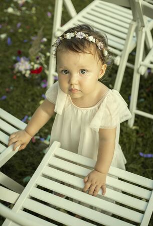 Cute baby girl in white dress on a family weddingの写真素材