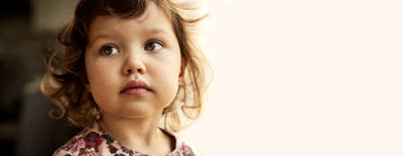 Close up portrait of a cute baby girl with blond curly hairの写真素材