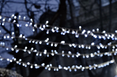 Abstract boken texture. Festive background. Glitter light spots on black background, defocused