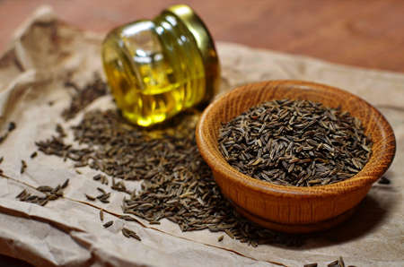 cumin oil with seeds on wooden backgroundの写真素材