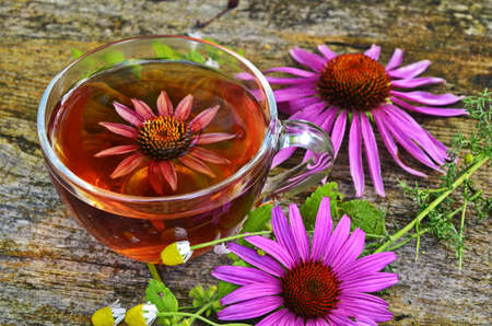 Cup of echinacea tea on old wooden tableの写真素材