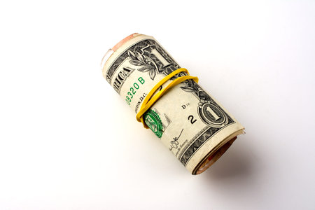 One and two dollars rolled into a tube on a white background.